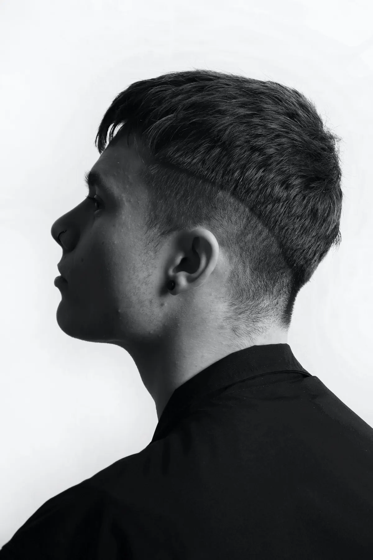 Zwart-witportret van een man met een strakke fade